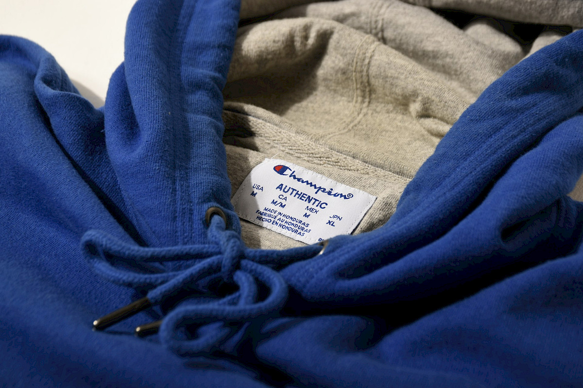 a close up of a blue hoodie with a tag on it. Photo by Bima Utomo, Unsplash.